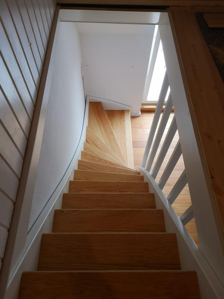Eine weiße Treppe mit hellem Holz