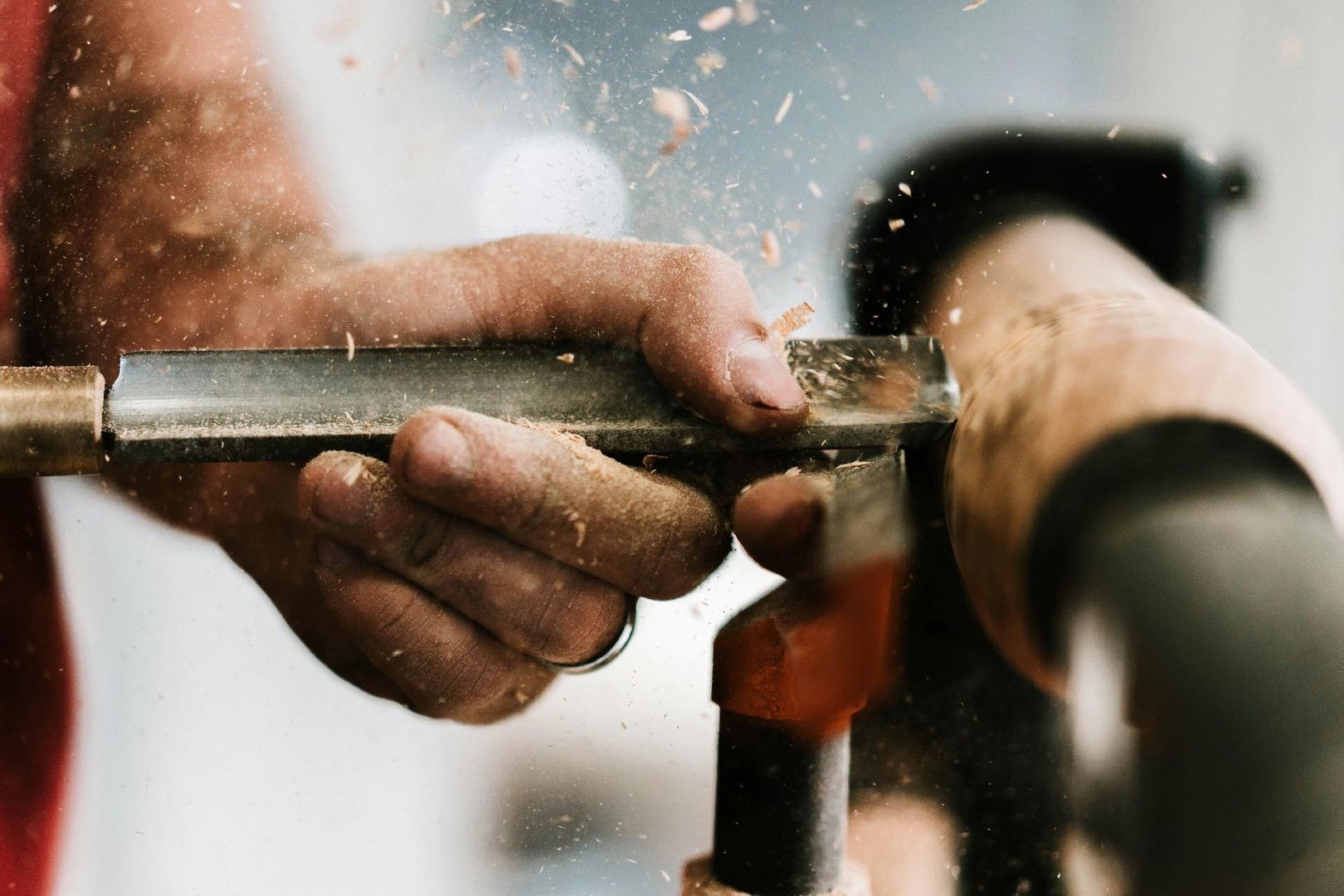 Hand eines Tischlers bei der Bearbeitung von Holz